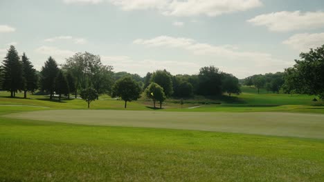 Orbiting-shot-of-a-golf-flag-on-the-green-waving-in-the-wind-on-a-golf-course