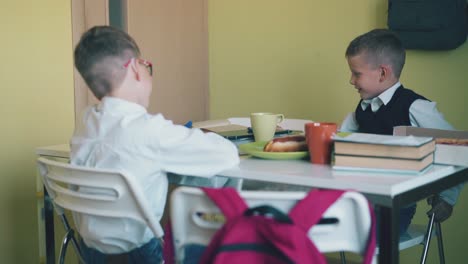 Schulkameraden-Ruhen-Sich-Am-Tisch-Mit-Essen-Und-Lehrbüchern-In-Der-Kantine-Aus