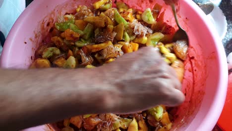 mixing up freshly made javanese rujak spicy fruit salad in southeast asia, close up of food preparation