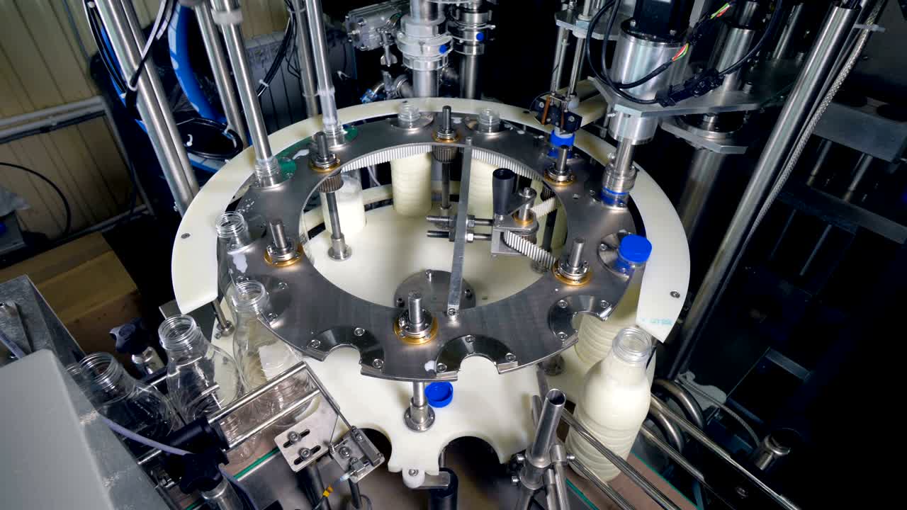 una línea de ruedas redondas que transporta botellas de leche para llenar.