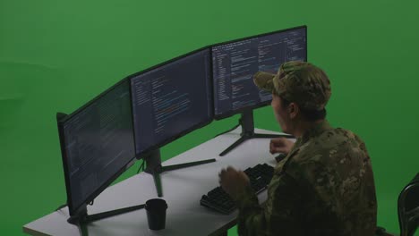 side view of happy asian man soldier developer celebrating while write code with multiple computer screens in green screen studio