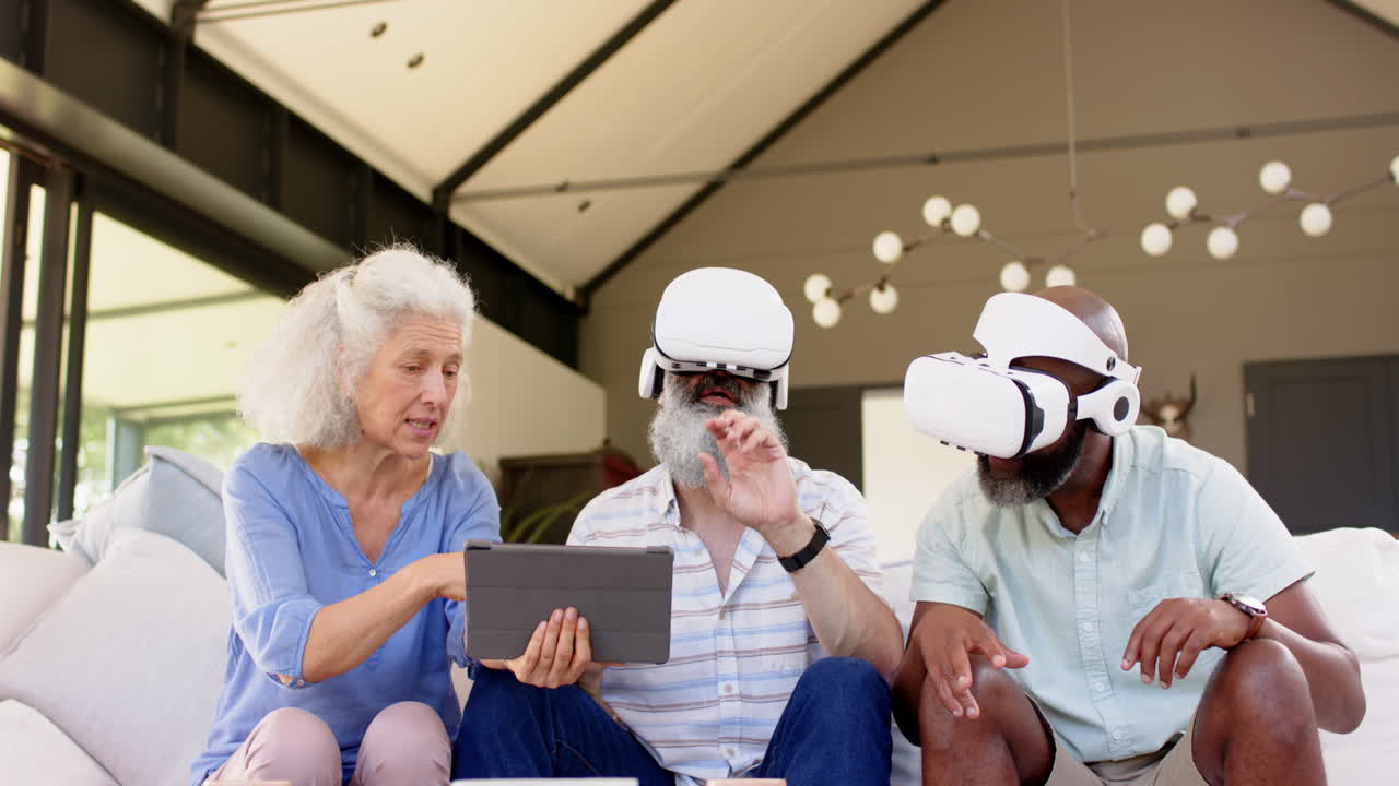 Using VR headsets, senior friends interacting with tablet on couch