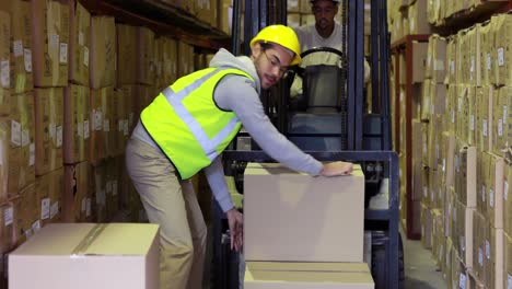 warehouse worker packing boxes on forklift