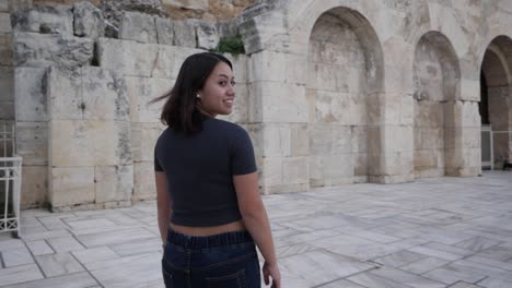 toma en cámara lenta de una mujer joven que camina y se da la vuelta y sonríe