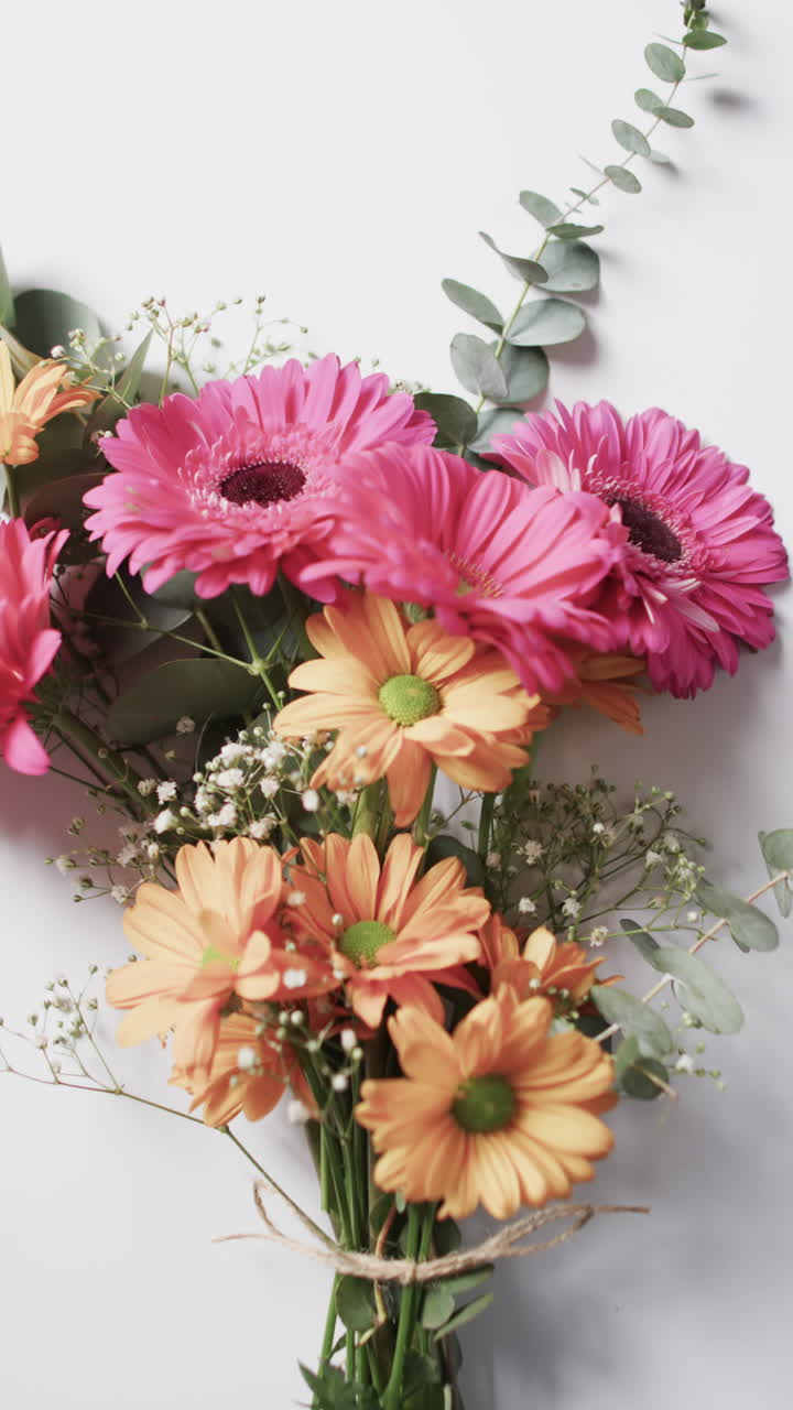 Video vertical de un ramo de flores amarillas y rosas con espacio para texto sobre fondo blanco