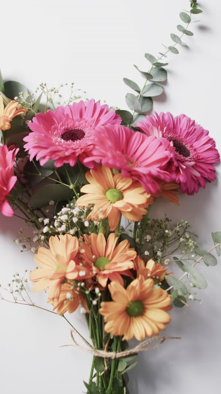 Video vertical de un ramo de flores amarillas y rosas con espacio para texto sobre fondo blanco