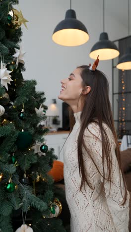 mujer admirando un árbol de navidad decorado