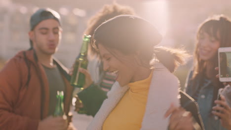 group-of-multiracial-friends-hanging-out-young-mixed-race-woman-dancing-enjoying-rooftop-party-at-sunset-drinking-alcohol-having-fun-on-weekend-celebration