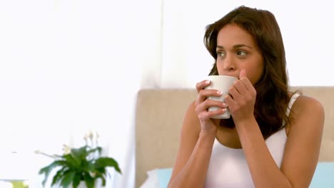 Happy-woman-having-tea-in-bed