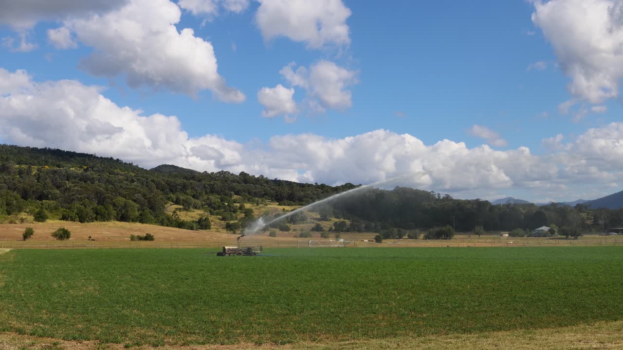 tractor regando el campo bajo un cielo azul