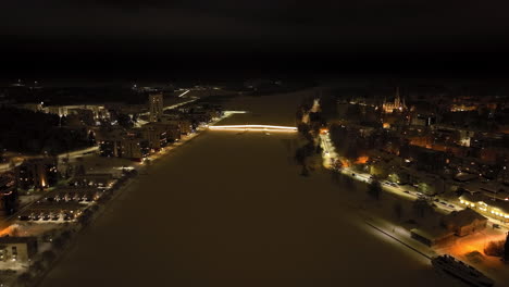drone flying toward the ylisoutajan silta bridge, winter night in joensuu, finland