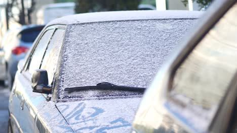 snowy cars parked on the street