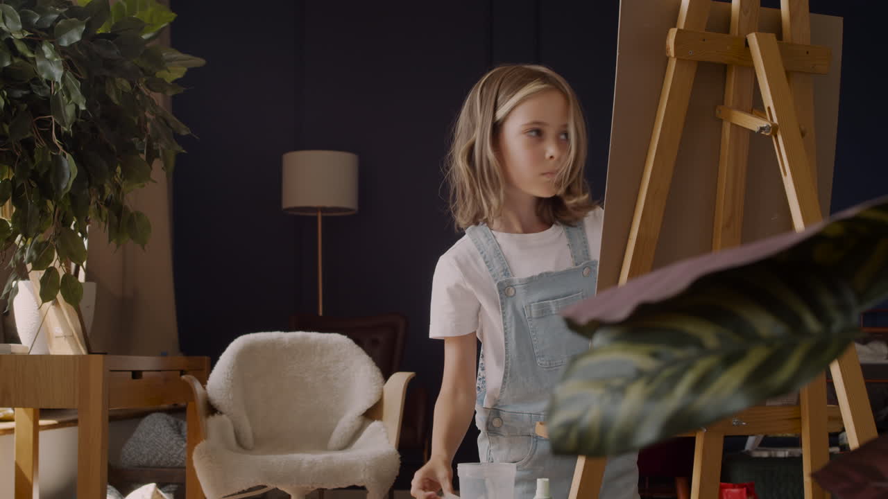 Little Blonde Girl Sticks Paper On The Lectern In The Living Room At Home 1