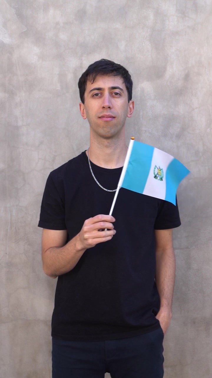 Toma vertical de un hombre ondeando la bandera guatemalteca en cámara lenta. Bandera de Guatemala.