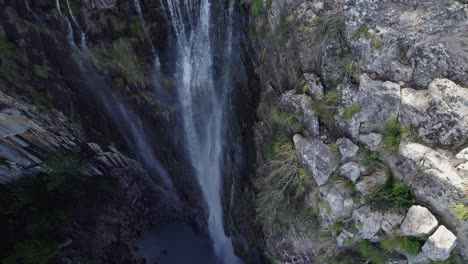 Minyon-Falls---Woman-Jumping-At-The-Lookout,-Waving-Its-Hand-To-The-Drone