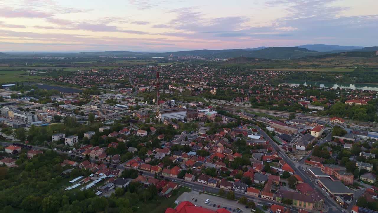 Aerial view of Dorog, Hungary, showcasing the town's layout, industrial areas and surrounding greenery during sunset
