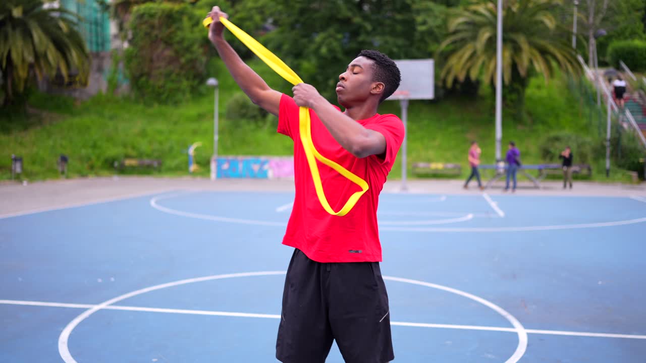 Young Man Exercising with Jump Rope on Basketball Court