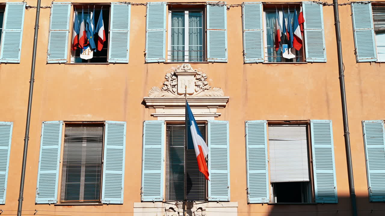 Old traditional building, with flags on the facade in Antibes, France