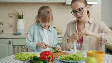 mother and daughter making a salad together