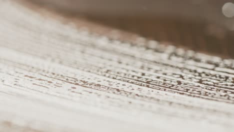 Macro-view-of-soapy-sponge-clean-spilled-soda-from-table