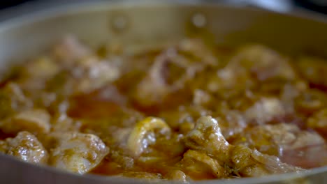 close up view of simmering chicken curry with bubbling curry sauce