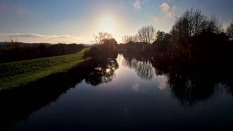 aerial drone footage moving slowly over a autumn river at the time of sunset