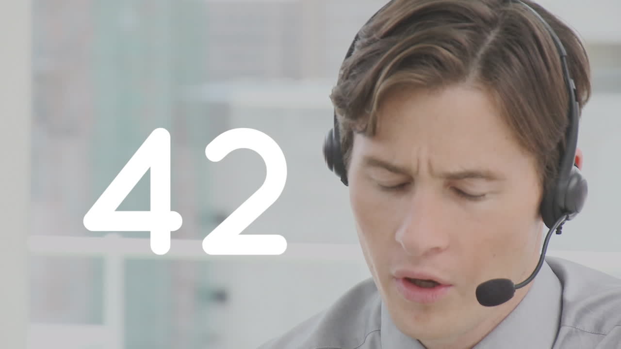 Changing numbers against caucasian male customer care executive talking on phone headset at office