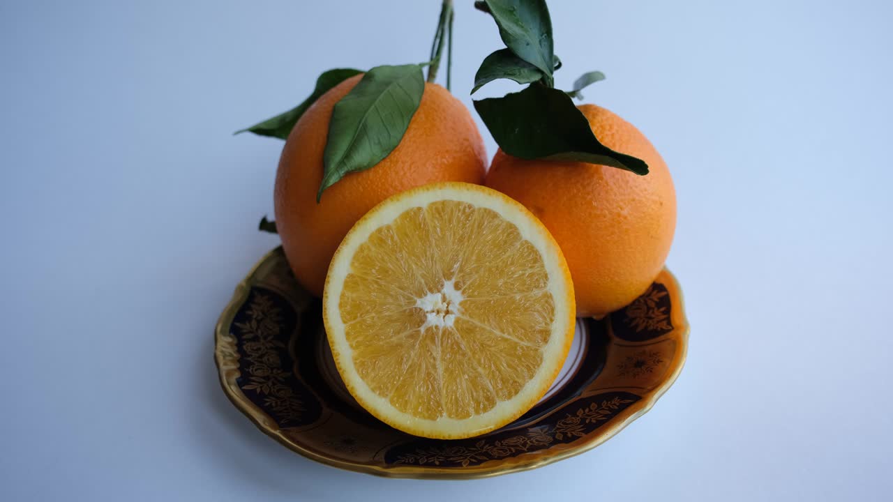 naranja madura y jugosa. naranja fresca cortada por la mitad sobre un fondo de naranjas con hojas