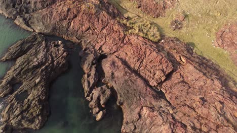 Isolated-and-unrecognizable-woman-walking-on-rocky-cliff,-Punta-Ballena