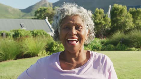 portrait of happy senior african american woman in garden on sunny day at retirement home