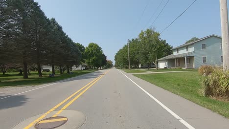 pov driving on a country road thru a small rural town in iowa usa