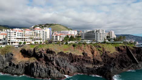 forward ascending drone shot of a mediran coast line showcasing all the idyllic hotels and the calm serene streets of portuguese life