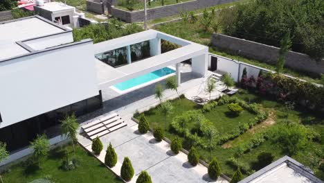 open air swimming pool in a minimal design luxury house in mountain forest woods tropical climate vegetation eco landscape design white color house modern architecture contemporary art in iran