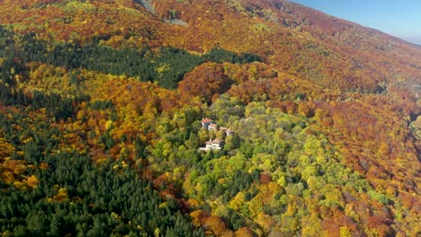 Hotel-Versteckt-Im-Herbstwald,-Umgeben-Von-Rotem,-Grünem-Und-Orangefarbenem-Laub