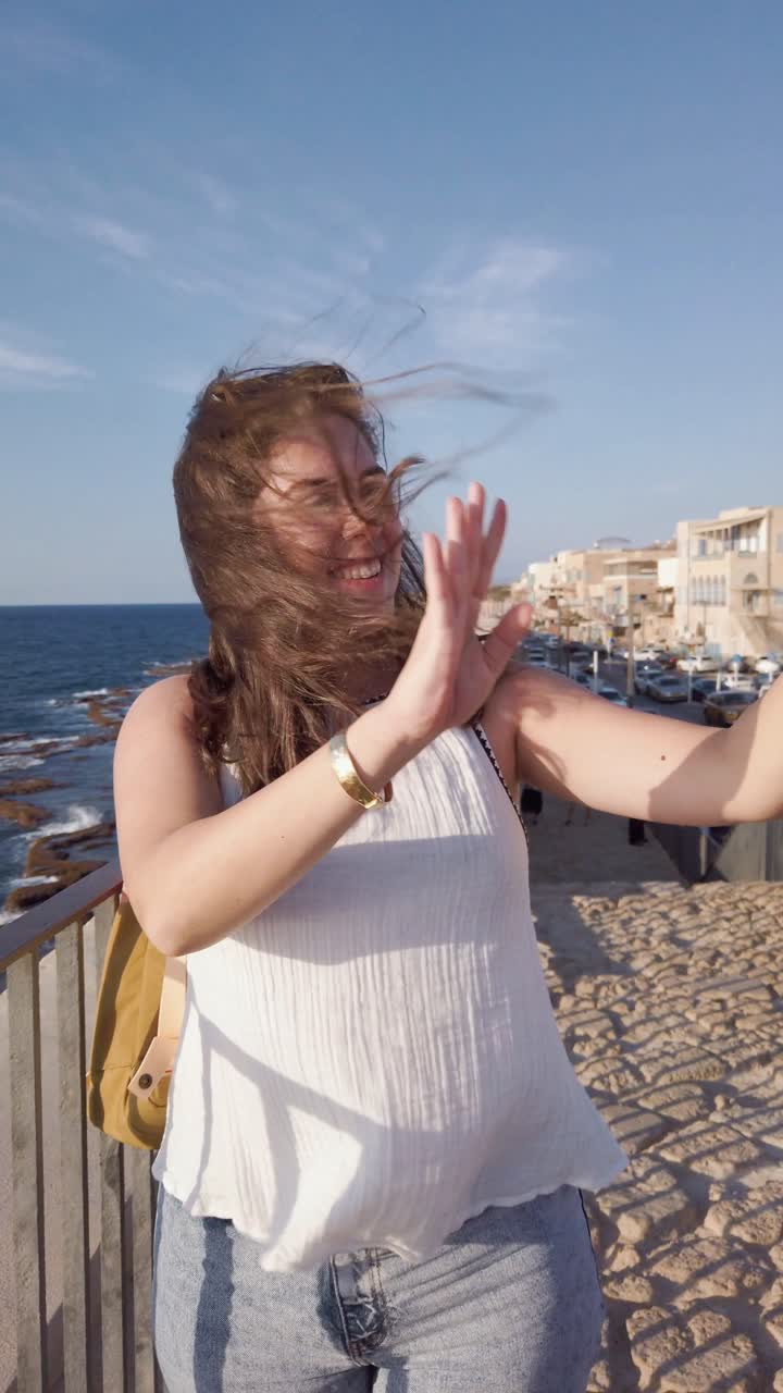 A woman is taking a picture of the sea with her cell phone in Acre old city, Israel
