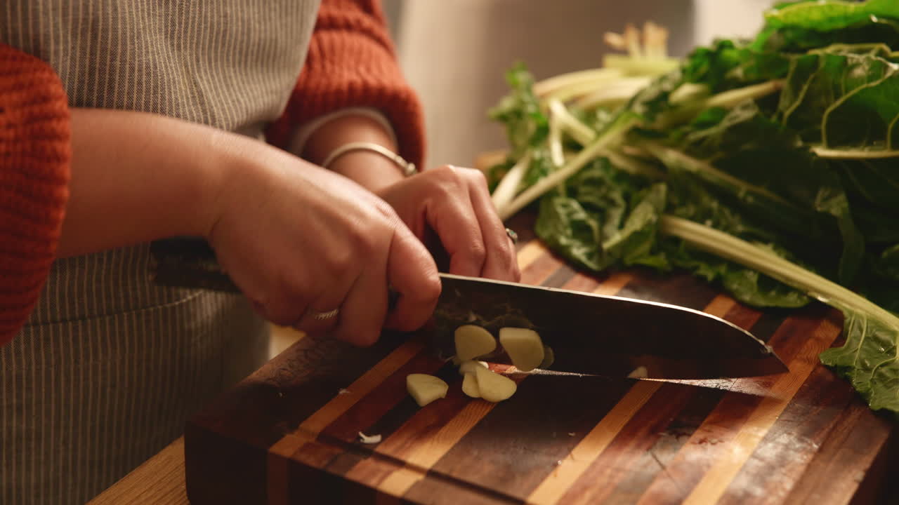 Woman Chopping Garlic in Kitchen