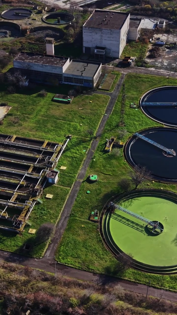 Water treatment facility with multiple tanks and green areas in view