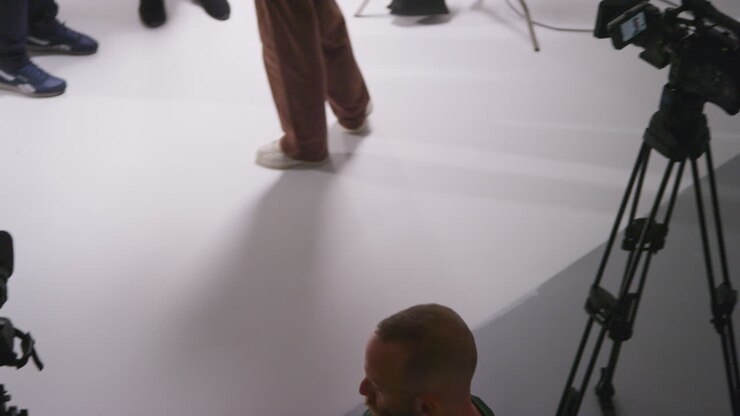 Overhead Shot Of Male Film Camera Operator Focusing Cameras Using Monitor Shooting Movie Or Video In Studio