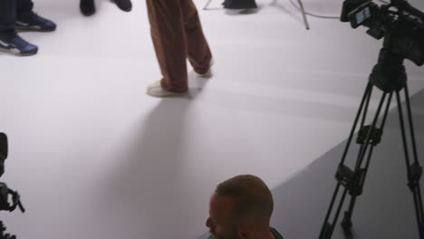 overhead shot of male film camera operator focusing cameras using monitor shooting movie or video in studio