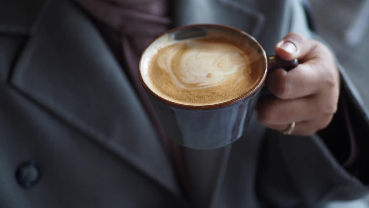 mujer disfrutando de un latte en un acogedor café