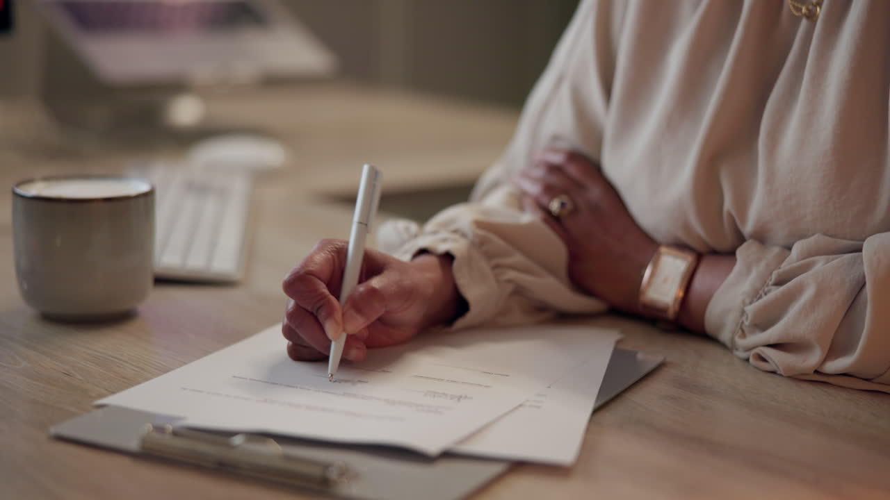 Woman signing a document at her desk