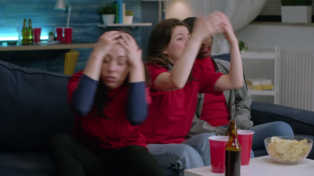 apoyan el fútbol animando juntos mientras ven el fútbol en la televisión