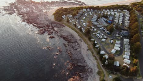 Flying-Over-Sea-Pool-Towards-Sunset,-Aerial-Tilt-Up