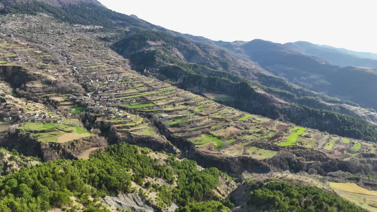 pueblo rural construido en la ladera de una montaña con parcelas de tierra fértil