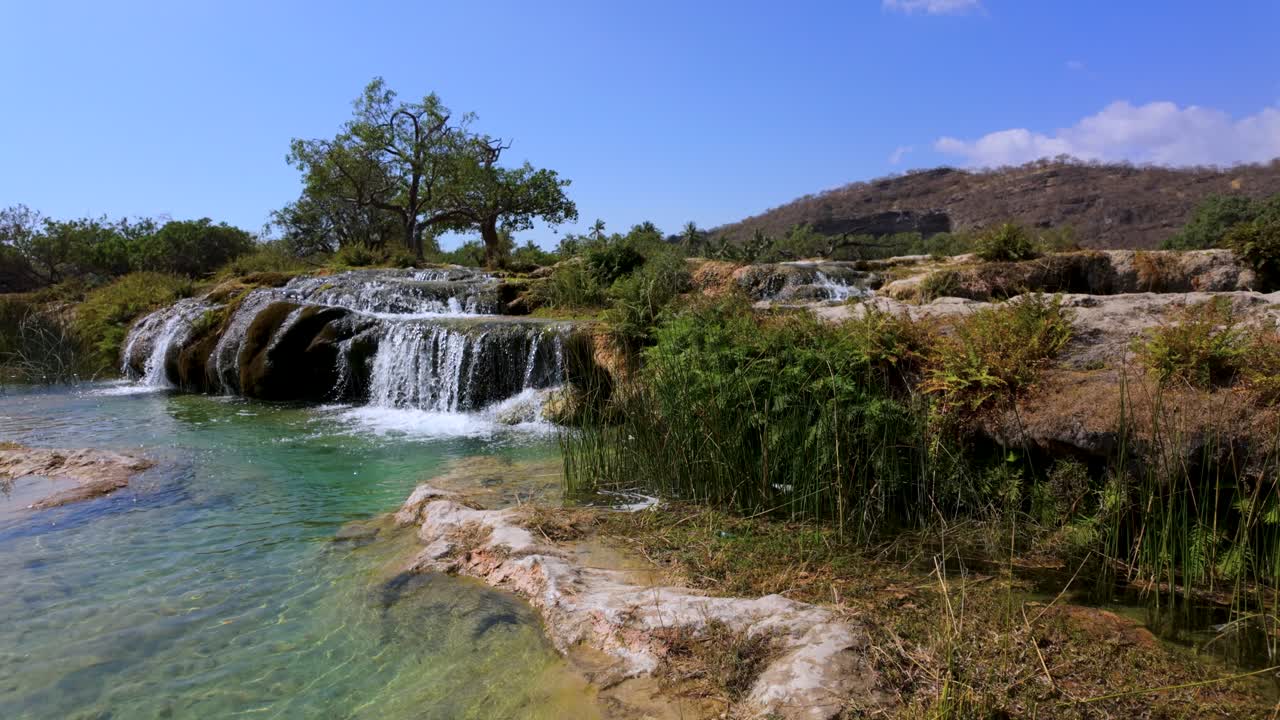 Wadi Darbat oasis, waterfalls, and natural spring with sparkling, clear water in Oman near Salalah