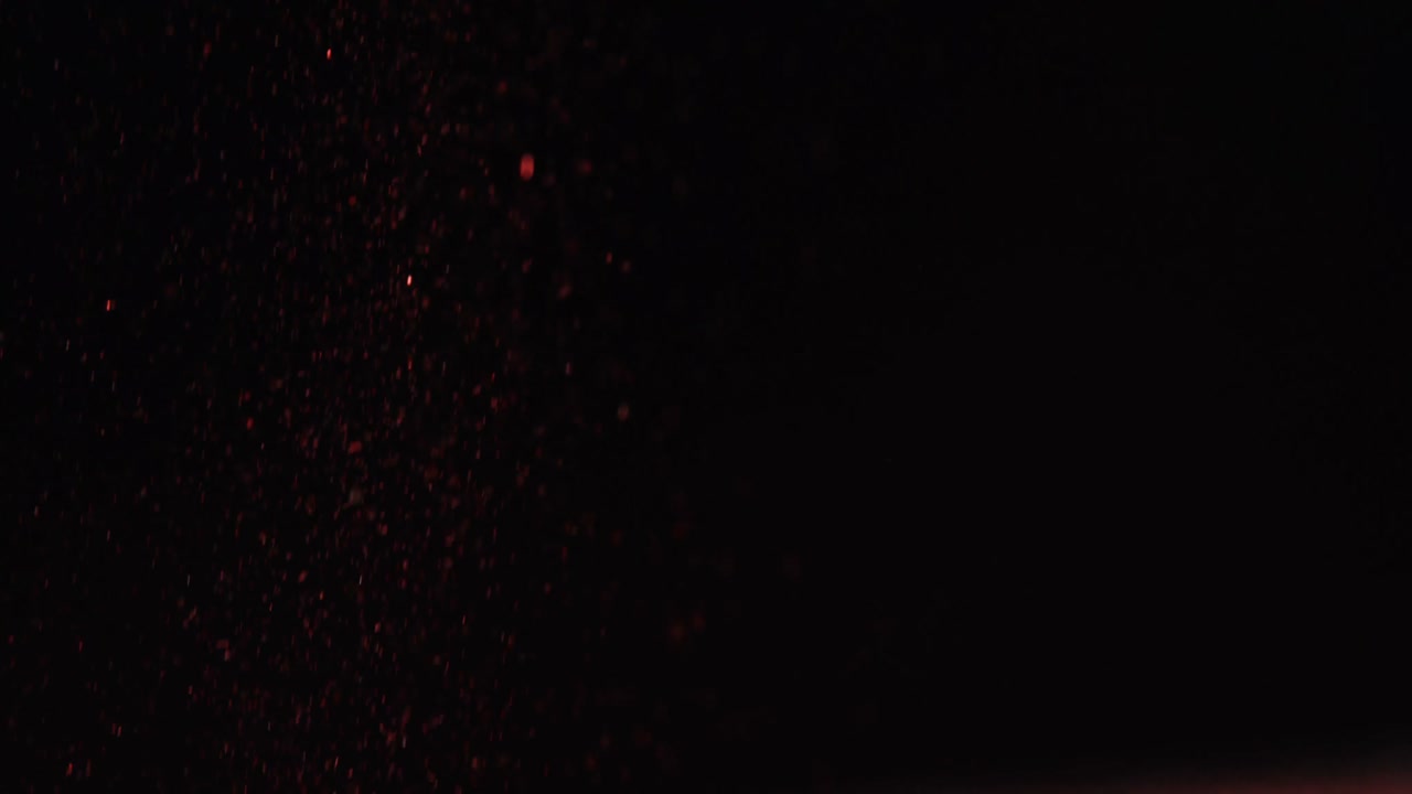 Close-up of glitter falling against black background 4k