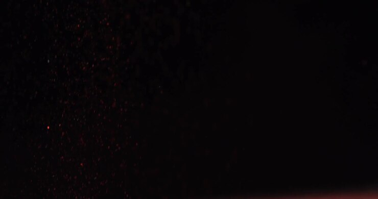 Close-up de glitter caindo contra fundo preto 4k