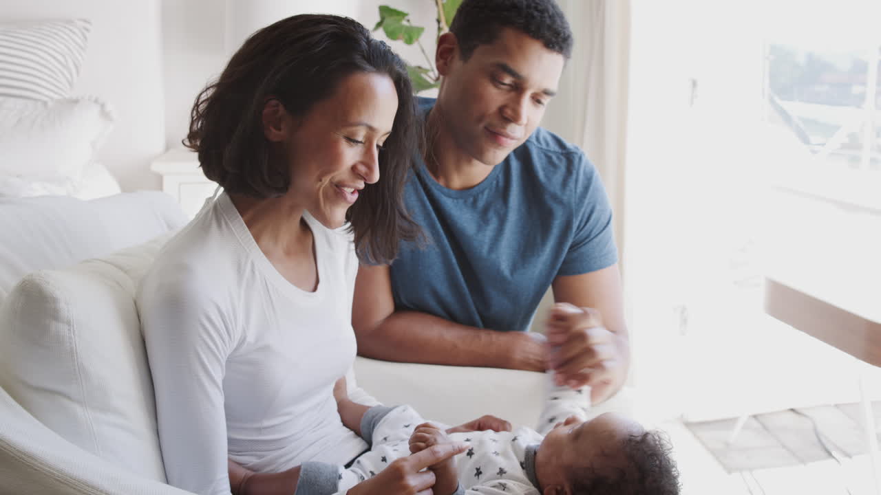 Happy young African American parents spending time with their baby son, close up, side view