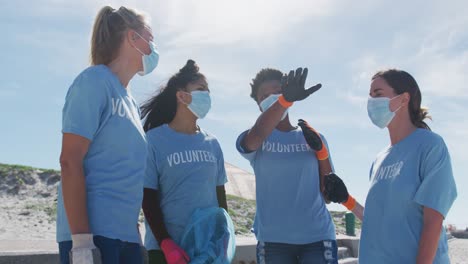 Diverse-group-of-women-wearing-volunteer-t-shirts-and-face-masks,-talking