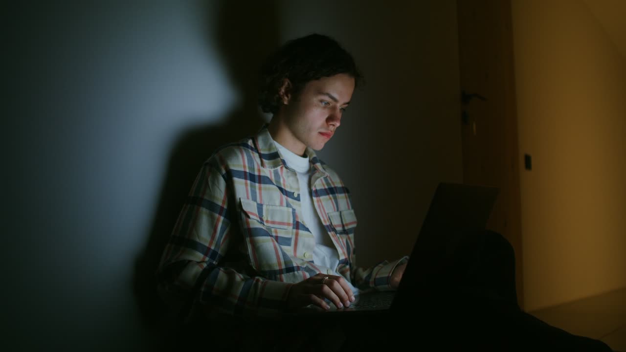 Young Man Working on Laptop at Night